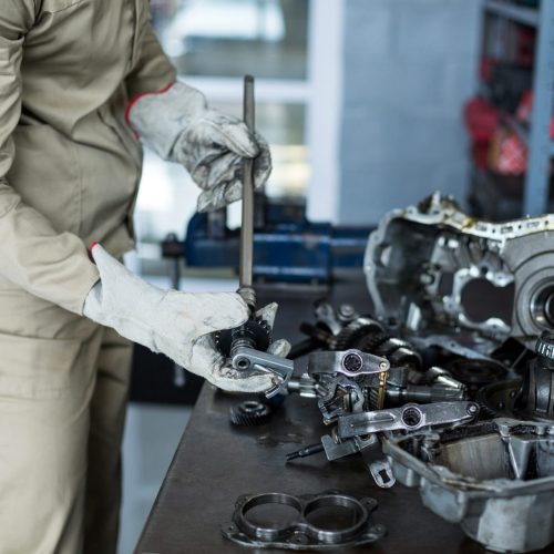 Mechanic checking a car parts in repair shop