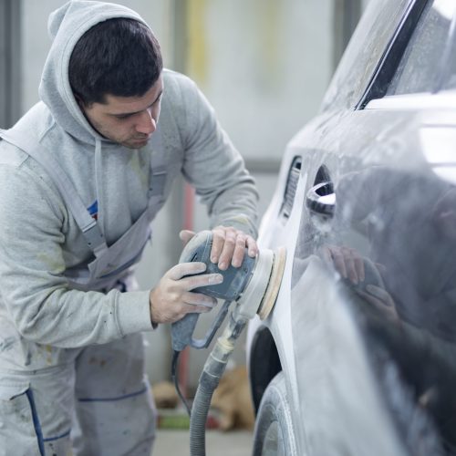 Shot of professional repairman preparing vehicle for new paint.
